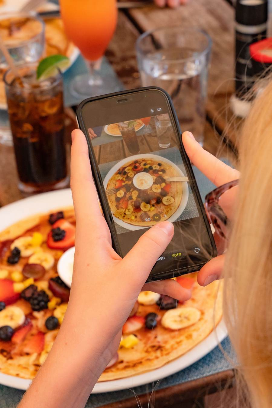 A guest photographing her loaded fruit pancake